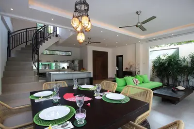 a dining room and living room with a table and chairs at Villa Jumah in Seminyak