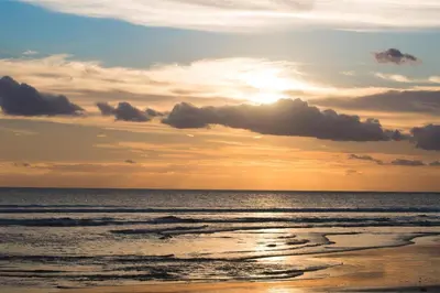 a sunset on a beach with the ocean at Hotel O Panen House in Seminyak