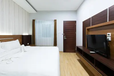 a bedroom with a bed and a flat screen tv at Casa Dasa Legian in Seminyak