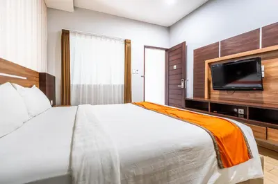a bedroom with a bed and a flat screen tv at Casa Dasa Legian in Seminyak