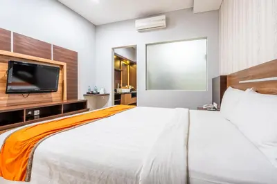 a bedroom with a large bed and a flat screen tv at Casa Dasa Legian in Seminyak