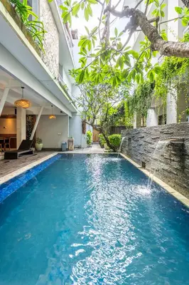 a swimming pool with a waterfall in a house at Casa Dasa Legian in Seminyak
