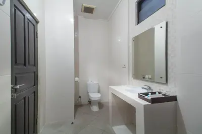 a bathroom with a sink and a toilet and a mirror at Bali Sandy Resort in Kuta