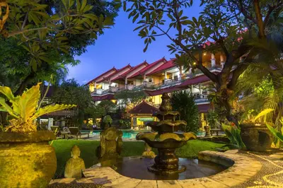 a garden with a fountain in front of a building at Bali Sandy Resort in Kuta