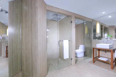 a bathroom with a shower and a toilet and a sink at Lv8 Resort Hotel in Canggu