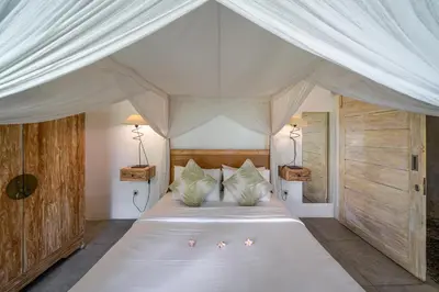 a bedroom with a white canopy bed with two lamps at Villa Palm Tree - Huge 4bd Villa CENTER SEMINYAK in Seminyak