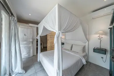 a bedroom with a white bed with a canopy at Villa Palm Tree - Huge 4bd Villa CENTER SEMINYAK in Seminyak