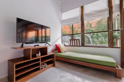 a bedroom with a bed and a flat screen tv at Alam Bidadari Seminyak in Seminyak