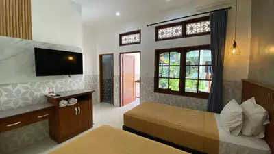 a hotel room with a bed and a television at Sandat Hotel Legian in Legian