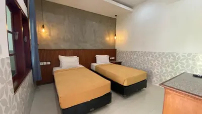 a small room with two beds in it at Sandat Hotel Legian in Legian