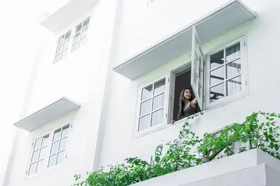 a woman looking out of a window at Umalas Suites in Seminyak