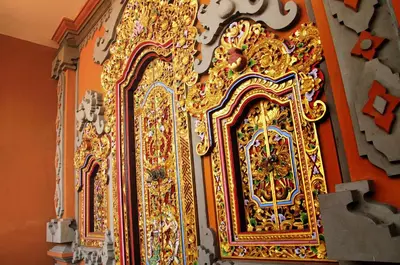 a gold clock on the wall of a room at Bemo Corner Guest House in Kuta