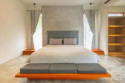a bedroom with a large bed and two windows at SooBali Niscala Villa 5 Bedroom in Canggu