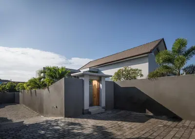 a house with a concrete wall and a fence at SooBali Niscala Villa 5 Bedroom in Canggu