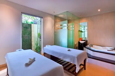 two beds in a room with a tub and a sink at Sun Island Boutique Villas & Spa Seminyak in Seminyak