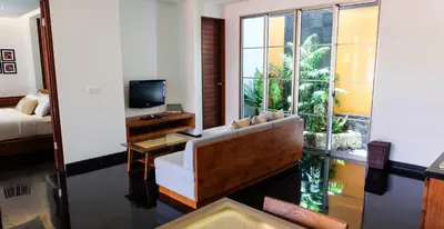 a living room with a couch and a television at Sun Island Boutique Villas & Spa Seminyak in Seminyak