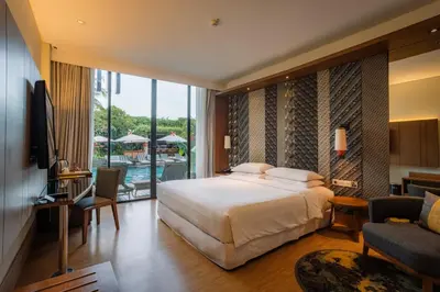 a bedroom with a bed and a balcony with a pool at Four Points by Sheraton Bali, Seminyak in Seminyak