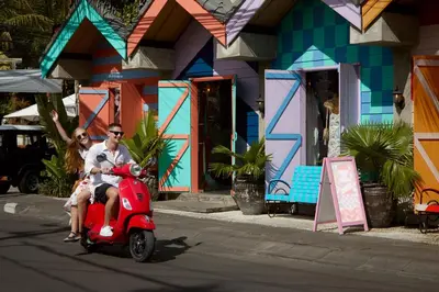 a man and woman riding a scooter in front of a building at Four Points by Sheraton Bali, Seminyak in Seminyak