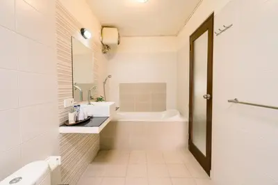 a white bathroom with a tub and a sink at Taman Bali Villas Dewi Sri in Legian