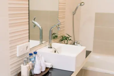 a bathroom with a white sink and a mirror at Taman Bali Villas Dewi Sri in Legian