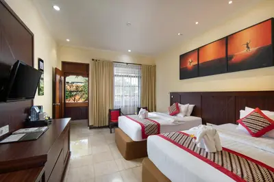 a hotel room with two beds and a flat screen tv at Grand Istana Rama Hotel in Kuta