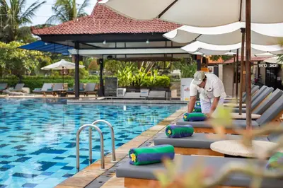 a man standing in front of a swimming pool at Grand Istana Rama Hotel in Kuta