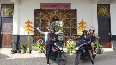 a group of people riding motorcycles in front of a building at Bali Bobo Hostel in Jimbaran