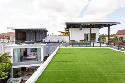 a house with a green lawn in front of it at The Jendela House in Canggu