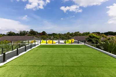 a large lawn in a house with green grass at The Jendela House in Canggu