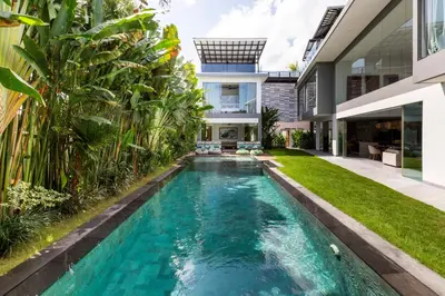 an infinity pool in the backyard of a house at The Jendela House in Canggu