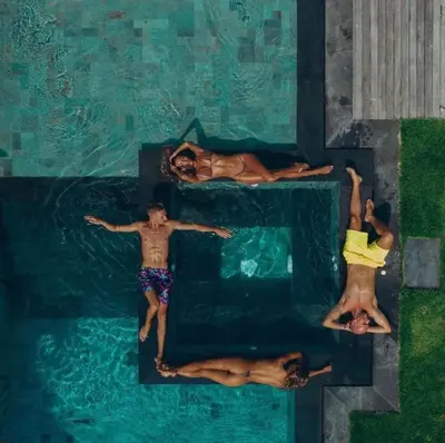 a group of people swimming in a swimming pool at The Jendela House in Canggu