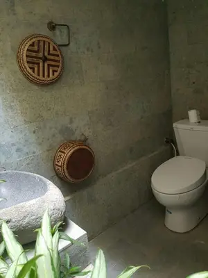 a bathroom with a toilet and a bath tub at Villa Rahayu in Seminyak