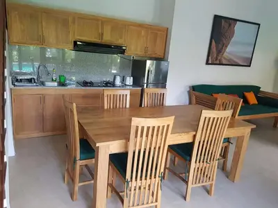 a kitchen with a wooden dining table and chairs at Villa Rahayu in Seminyak