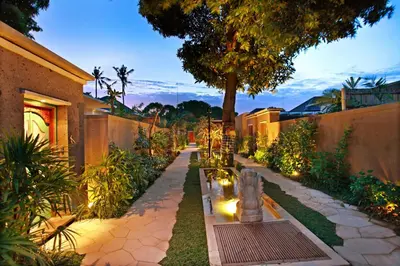 a garden with a bench and a tree and lights at New Pondok Sara Villas in Seminyak