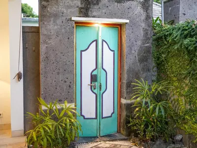 a blue door with a stained glass window at New Pondok Sara Villas in Seminyak