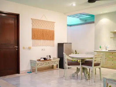 a kitchen with a table and chairs and a refrigerator at New Pondok Sara Villas in Seminyak