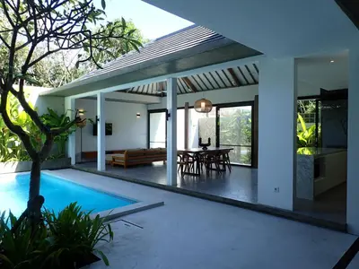 a house with a swimming pool and a patio at Villa Hujan in Seminyak