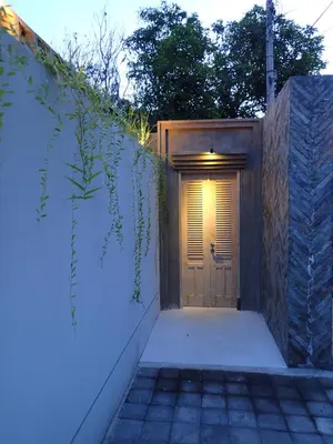 a wooden door with a light on top of it at Villa Hujan in Seminyak