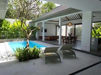 a villa with a swimming pool and a patio at Villa Hujan 2 in Seminyak