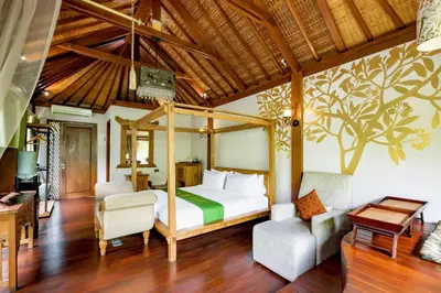 a bedroom with a bed and two chairs in a room at DISINI Luxury Spa Villas-CHSE Certified in Seminyak