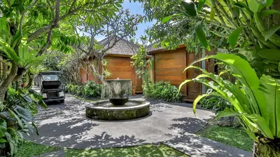 a garden with a fountain in the middle of a yard at DISINI Luxury Spa Villas-CHSE Certified in Seminyak
