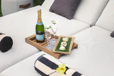 a bottle of champagne on a tray with glasses on a couch at Villa Dewata One in Seminyak