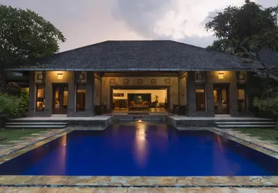 a house with a blue pool in front of it at Villa Dewata One in Seminyak