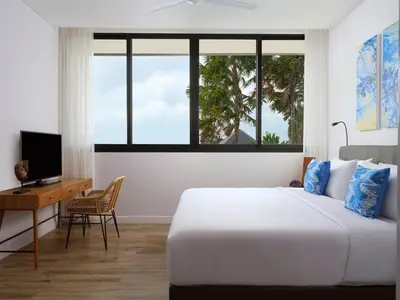 a bedroom with a bed and a desk with a television at Avani Seminyak Bali Resort in Seminyak