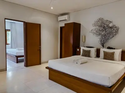 a bedroom with a large bed with white sheets at Villa Chocolat Seminyak in Seminyak