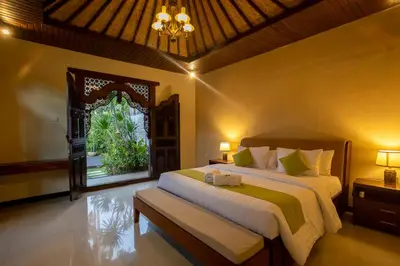 a bedroom with a large bed and a window at Villa Katara in Seminyak