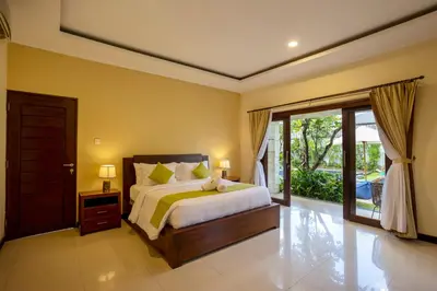 a bedroom with a bed and a sliding glass door at Villa Katara in Seminyak