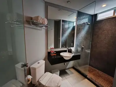 a bathroom with a toilet and a sink and a shower at Loft Legian Hotel Bali in Legian