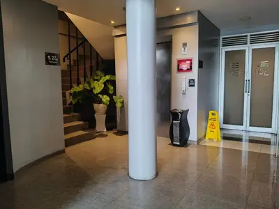 a lobby with a column and stairs in a building at Loft Legian Hotel Bali in Legian