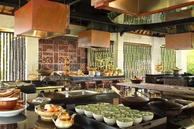 a large kitchen with many bowls of food in it at AYANA Resort Bali in Jimbaran